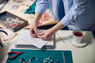 Kadının elleri müşteriler için hediye hazırlıyor.