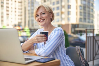 Kahve molasında gevşeyen neşeli bayan.