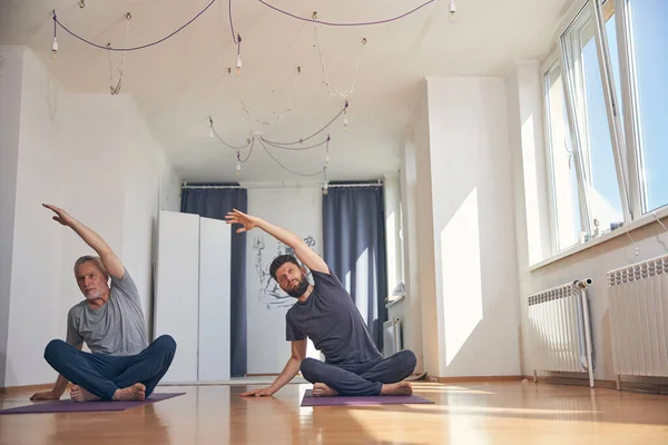 Dos hombres caucásicos flexibles practicando yoga juntos — Foto de Stock