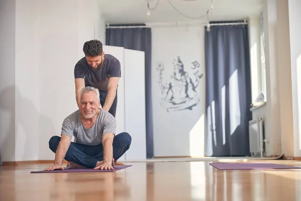 Kezdő jógi gyakorlatot végez az oktatója segítségével. — Stock Fotó