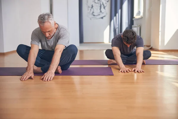 Σύγχρονη yogis κάνει μια άσκηση τέντωμα σε εσωτερικούς χώρους — Φωτογραφία Αρχείου