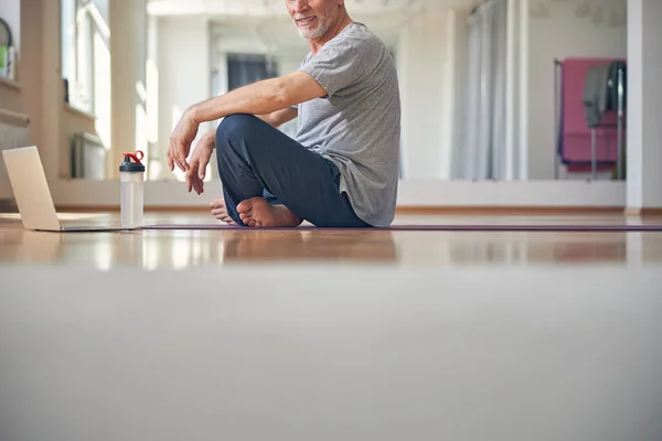Yoga minderinde eşofmanlı çıplak ayaklı adam. — Stok fotoğraf
