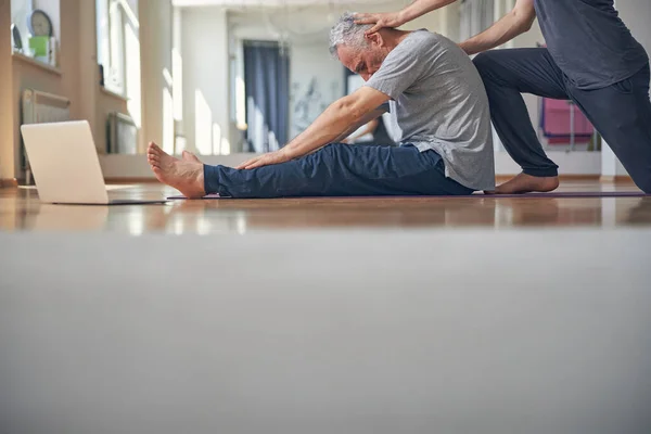 Uomo caucasico facendo una curva in avanti seduto — Foto Stock