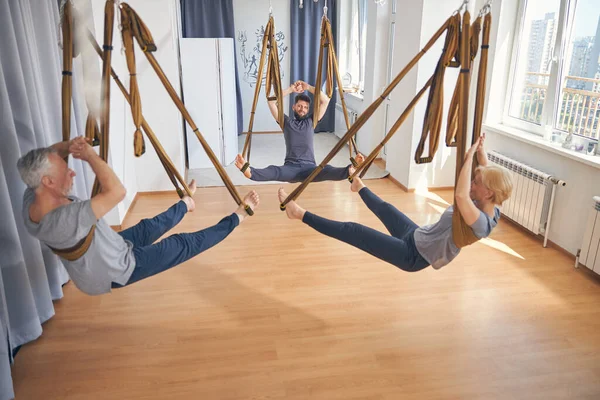 Entraîneur qualifié et débutants pratiquant le yoga anti-gravité — Photo