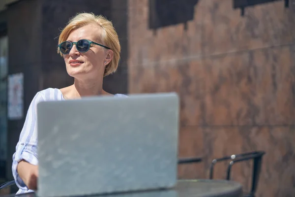 Mujer con gafas de sol mirando a la distancia —  Fotos de Stock