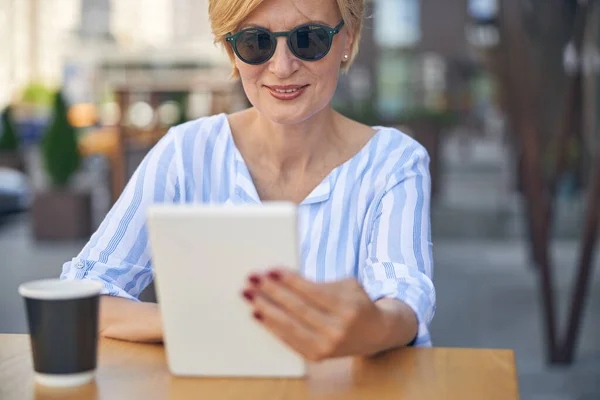 Femme d'affaires avec un gadget à une table en bois — Photo
