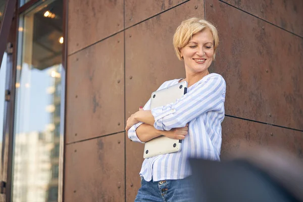 Bilgisayarlı gülümseyen bayan aşağıya bakıyor.