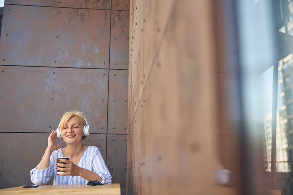 Señora alegre en auriculares disfrutando de sus canciones favoritas —  Fotos de Stock