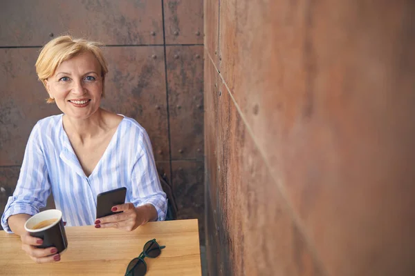 Mujer rubia sonriente con un teléfono celular — Foto de Stock