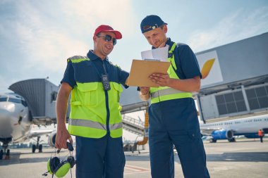 Havalimanında ayakta duran iş elbiseli adamlar.