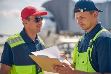 Düşünceli genç adam panoya bakıyor.