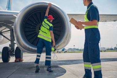 Yönetici ve meslektaşı bir hava aracını inceliyor.