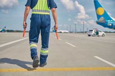 Kafkasyalı havaalanı çalışanı bir uçağa doğru gidiyor.