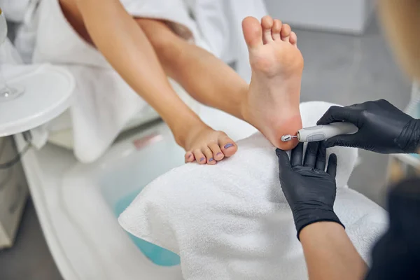 Vrouw op bezoek bij schoonheidsspecialiste voor hardware pedicure in salon — Stockfoto