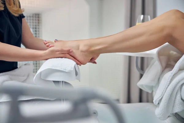 Nail artist massaggiare piedi femminili dopo pedicure — Foto Stock