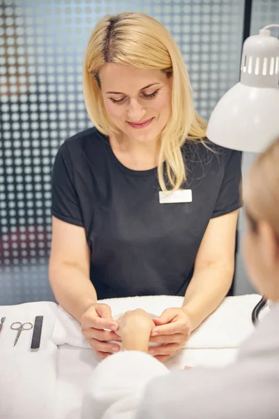 Esteticista feminina feliz fazendo manicure para mulher — Fotografia de Stock