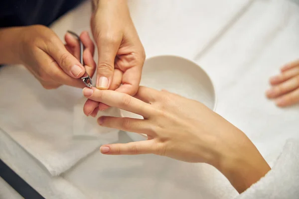 Artista de uñas usando pinza para clientes en el trabajo —  Fotos de Stock
