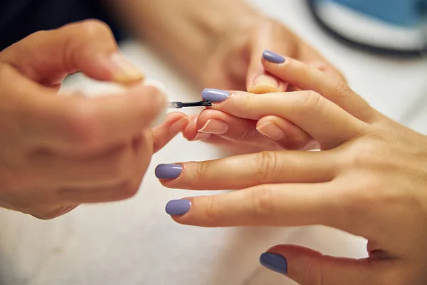 Las manos femeninas durante el procedimiento de manicura en el salón —  Fotos de Stock