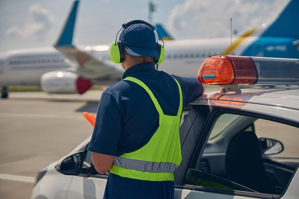 Trabajador del aeropuerto mirando el avión aterrizado — Foto de Stock