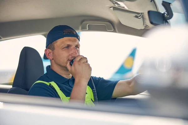 Airport car driver speaking into the microphone — Stock Photo, Image