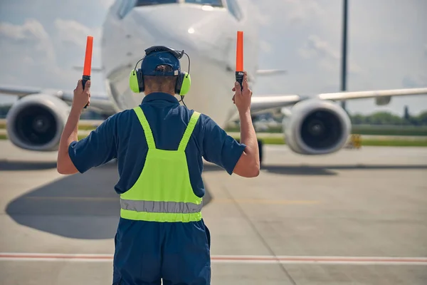 Marshaller in the safety overalls signaling the pilot — Stock Photo, Image