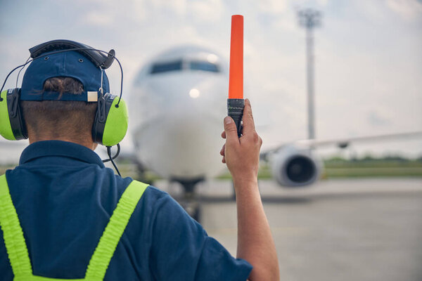 Рабочий мужчина держит поднятую правую руку