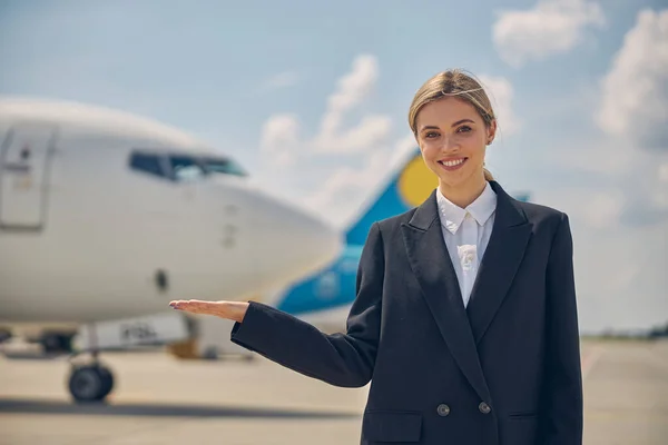 Joven empleado de la aerolínea sonriendo a la cámara — Foto de Stock