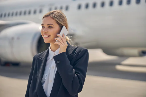 Kvinna med en smartphone på flygplatsen — Stockfoto