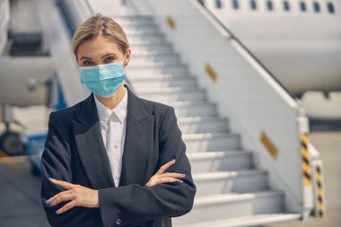 Kameraya poz veren maskeli bir kadın.
