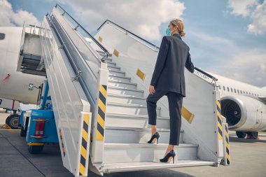 Havayolu işçisi tırabzana tutunuyor.