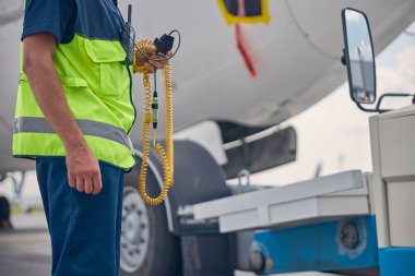 Havaalanında telsizi olan bir erkek işçi.