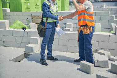 İnşaat alanında birbirlerini selamlıyorlar.