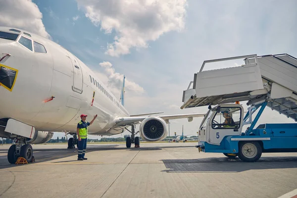 Experienced airport worker directing the ground vehicle operator — Stock Photo, Image