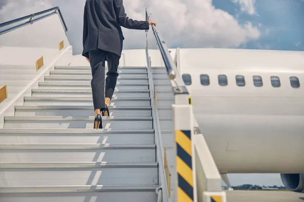 Vrouw op weg naar de ingang van het vliegtuig — Stockfoto