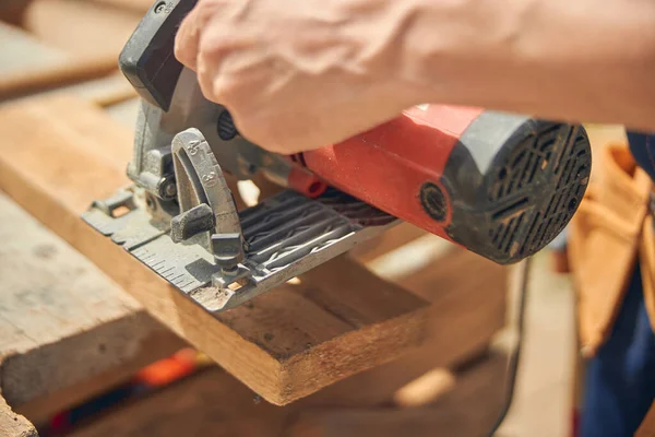 Trabajador masculino cortando un pedazo de madera — Foto de Stock