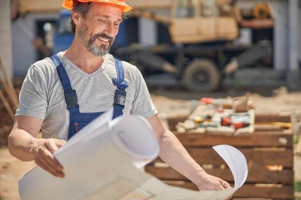 Sorrindo homem olhando para um plano de casa — Fotografia de Stock