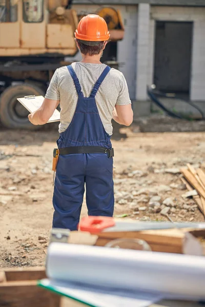 Homem de capacete a olhar para um veículo — Fotografia de Stock