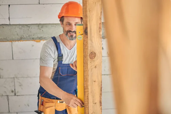 Trabajador masculino sonriente usando una herramienta de construcción — Foto de Stock