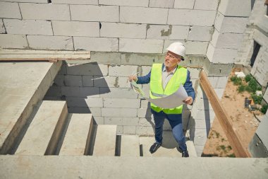 Üst düzey bir erkek inşaat aletine bakıyor.