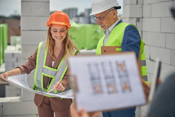 Man in eyeglasses listening to his cheerful female colleague