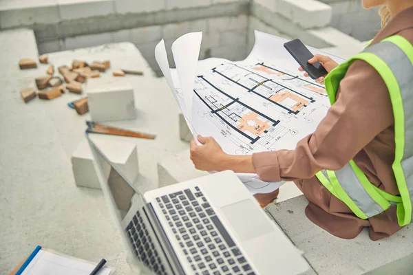 Mulher segurando um plano de casa e um celular — Fotografia de Stock