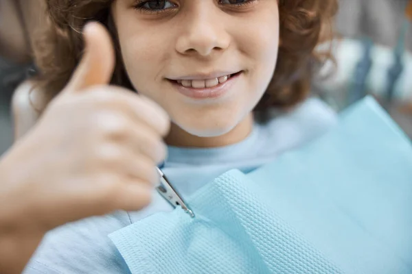 Pozitivní dítě držící palce během lékařské prohlídky — Stock fotografie