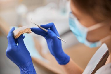 Hasta çenesinin alçı modeline bakan ortodontist