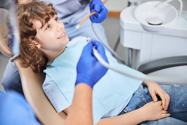 Positive-looking kid is getting a dental treatment — Stock Photo, Image