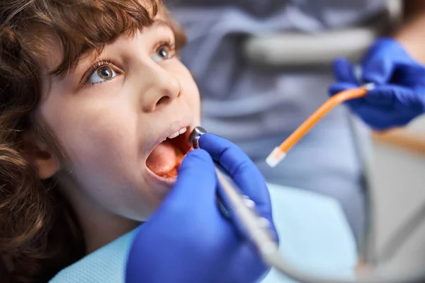 Brown-haired child opening mouth for dental treatment — Stock Photo, Image