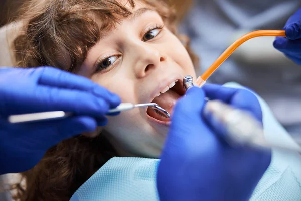 Cute curly kid going well through dental treatment — Stock Photo, Image