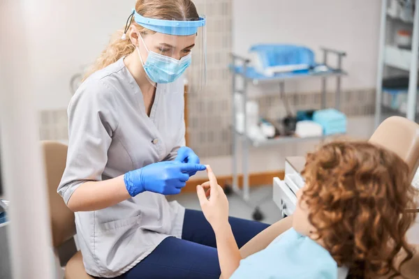 Il dentista e il suo paziente bambino stanno toccando le dita — Foto Stock