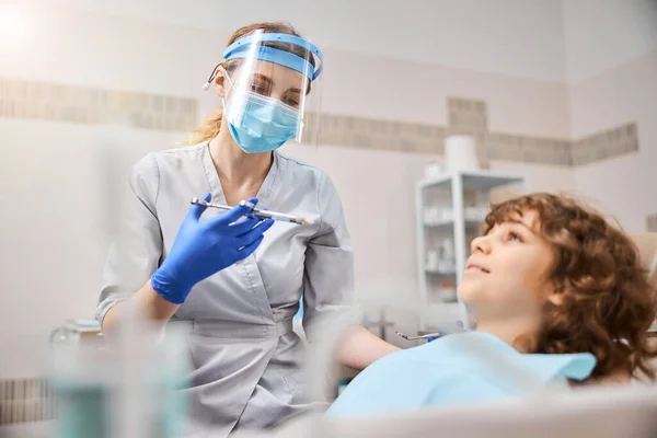 Dentiste qualifié donnant un coup d'anesthésique à l'enfant — Photo