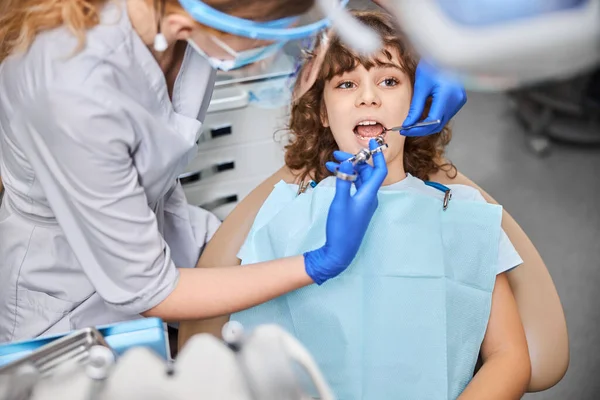 Specialista dentista ben addestrato che dà anestesia a un bambino — Foto Stock