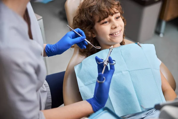 Smiley kid sitting in a dental chair ready for treatment — Stock Photo, Image